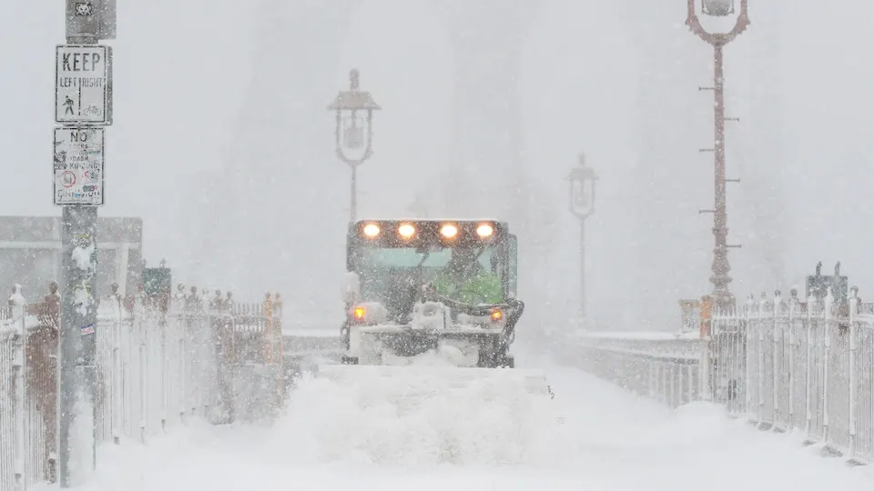 Une déneigeuse se fraye un chemin sur un passage enneigé.