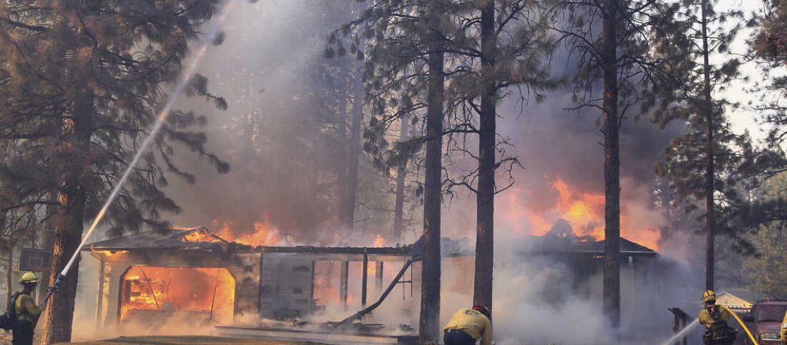 California Department of Forestry and Fire Protection firefighters try to stop flames from the Mill Fire from spreading on a property in the Lake Shastina subdivision northwest of Weed, Calif., Friday, Sept. 2, 2022. (Hung T. Vu/The Record Searchlight via AP)