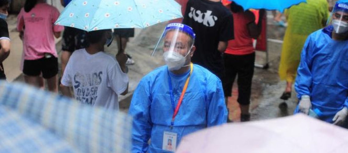 A medical worker looks on as residents and tourists queue to undergo nucleic acid tests for the Covid-19 coronavirus in Sanya in China's southern Hainan province on August 8, 2022. China OUT
 (Photo by AFP)